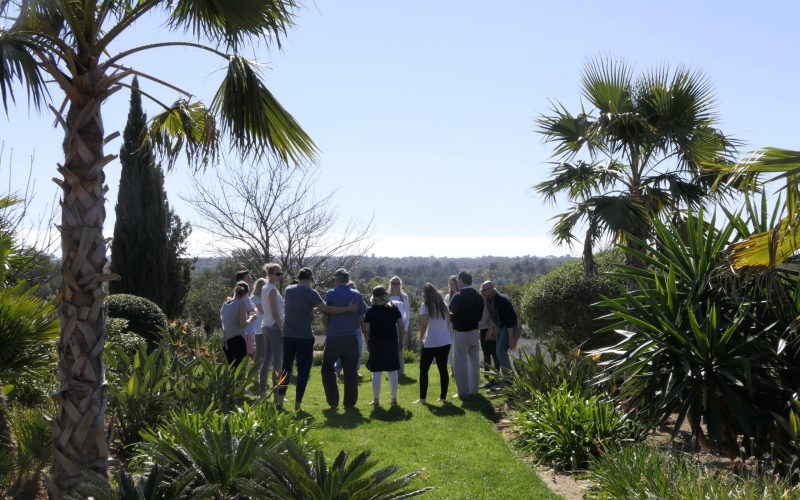 Eine Gruppe tauscht persönliche Erfahrungen aus, während sie in dem Garten von der Finca Can Ferragut wandern