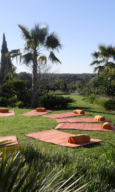 Ruhiger Meditationsplatz im Garten, umgeben von grüner Natur und mediterranen Pflanzen