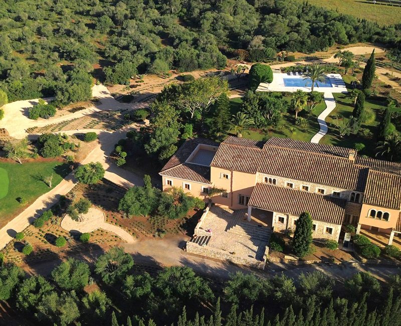 Drohnenblick auf die Finca Can Ferragut, umgeben von dem idyllischen Garten und einem Pool